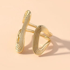 Makro-Detail eines goldenen geometrischen Rings mit konzentrischen Rillen und Linien