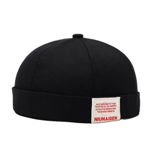 Klassische schwarze Baumwoll-Dockermütze mit weißem Patch-Label auf weißem Hintergrund