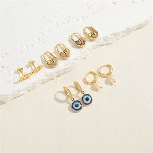 Detail view of 14K gold plated heart lock and evil eye earrings with freshwater pearls