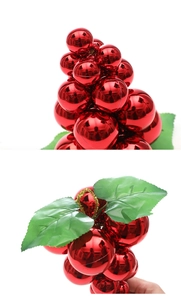 Close-up of shiny red grape-shaped Christmas ball ornaments with green leaves for decor