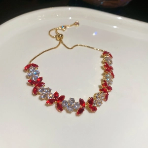 Detail of adjustable gold bracelet featuring marquise red and round white zircon stones