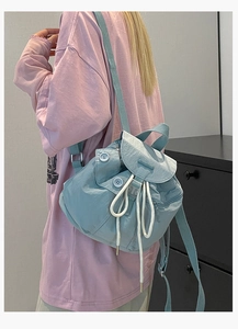 Detail of light blue nylon mini bucket backpack with drawstring and flap closure