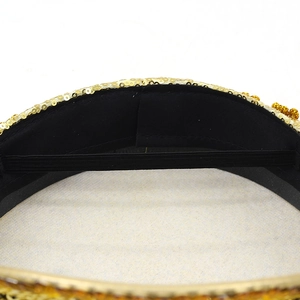 Detailed macro view of golden sequins fringe and black fabric lining on a bridal hat