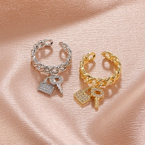 Detail of Cuban chain open rings with crystal-encrusted lock and key charms