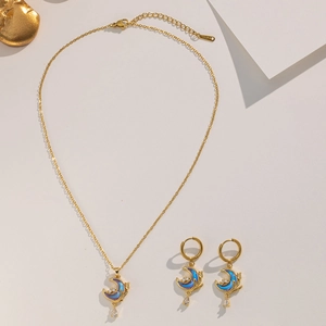 Detailed macro of golden crescent moon necklace and earrings set with blue zircons