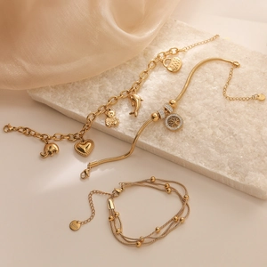Gold plated stainless steel bracelet set with tree of life and animal charms on silk