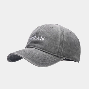 Detailed embroidery of white MILAN text on a vintage washed grey cotton baseball cap