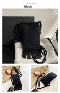 Macro shot of black retro suede tote bag featuring long decorative tassels and thin strap