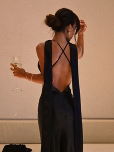 Elegant black backless halter dress with criss-cross straps and long flowing streamers