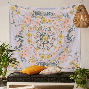 Floral mandala tapestry in warm pink and orange tones hanging above a cozy bench