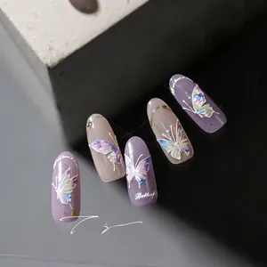 Macro detail of 3D butterfly nail charms on light purple and nude gray manicure stickers