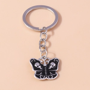 Macro shot of silver alloy butterfly keychain with black skull enamel details