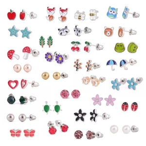 Detailed flat lay of diverse minimalist earrings set including pearls and nature motifs