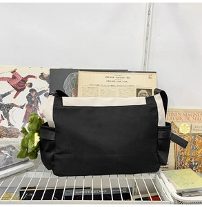 Detail of canvas messenger bag with green dinosaur pendant on vintage shelf display