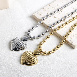Minimalist heart-shaped shell pendant necklaces in gold and silver finish on stones