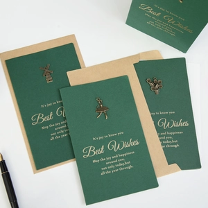 Vintage green greeting card set with gold foil text, metal charms, and kraft envelopes