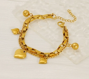 Détail du bracelet multicouche en acier titane doré avec cœurs et perles