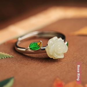 Macro shot of white resin rose ring with enamel leaf on adjustable silver band