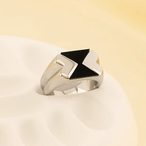 Dettaglio anello in acciaio argento con intarsio in smalto nero a triangolo su supporto