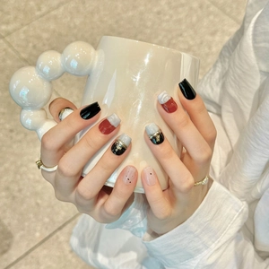 Handmade short press-on nails with dark red and black marble finish and gold foil accents