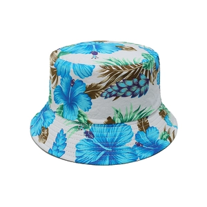Détail de motifs de feuilles tropicales turquoise et fleurs sur un chapeau bob en toile