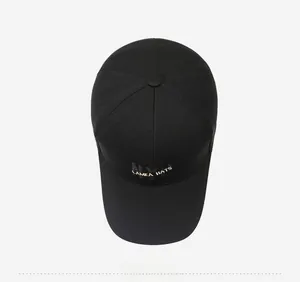 Detailed embroidery of gold LAMEA HATS text on black canvas baseball cap texture