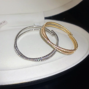 Vue macro des bracelets croisés en or et argent sertis de zircons cubiques scintillants