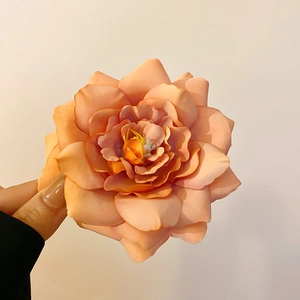 Detailed view of peach fabric rose hair clip showing realistic petals and soft texture