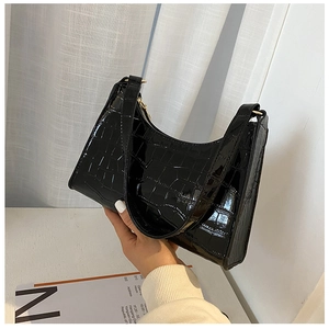 Close-up of black crocodile pattern leather underarm bag with sleek metal zipper detail