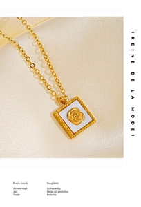 Macro detail of gold square pendant with rose engraving on silk background