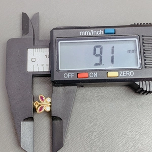 Macro shot showing crystal butterfly pendant size 9.1mm with digital caliper measurement