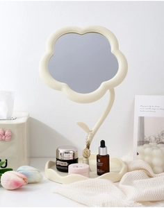 Détail du miroir de courtoisie en forme de fleur avec cadre beige et plateau de rangement