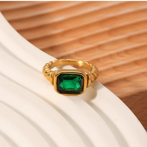 Detail of emerald green rectangular gemstone set in a golden twisted rope ring band