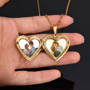 Close-up of golden heart locket pendant opening to reveal two custom photos inside