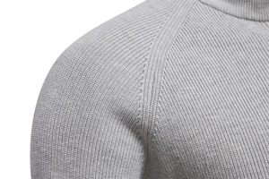Detailed close-up of gray knit fabric shoulder stitching on a men's winter sweater