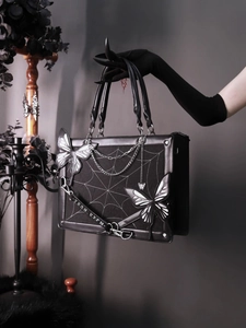 Gothic black tote bag featuring cobweb stitching, butterfly accents, and metal chains