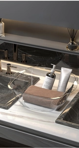 Transparent plastic washbasin with handles showing storage for towels and toiletries