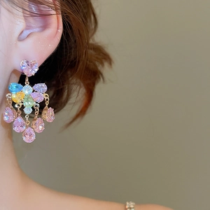 Detail of colorful crystal tassel earrings with sparkling heart and teardrop stones