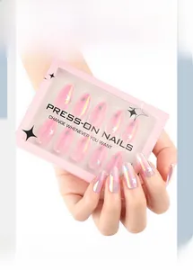 Close-up of pink iridescent almond press-on nails with white star patterns in packaging