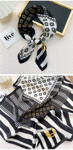 Detail of silk scarf showing houndstooth and geometric patterns on white textured surface