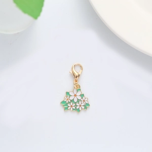 Detail of white daisy flower keychain with golden clasp and green enamel leaves