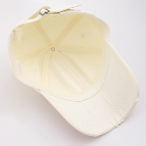 Detail view of cream washed denim baseball cap featuring distressed edges and metal buckle
