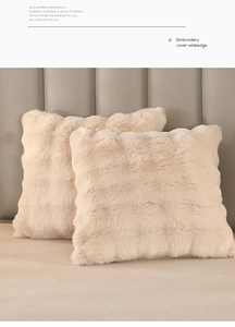 Detail of beige faux fur plush pillows showing soft texture and wide embroidery edges