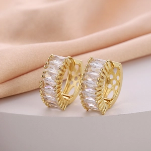 Macro shot of gold-plated hoop earrings featuring rectangular cubic zirconia and cutouts