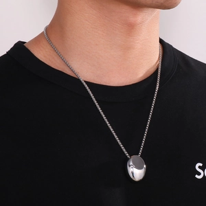 Men's polished stainless steel water drop pendant necklace shown on a black T-shirt