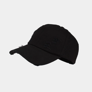 Close-up of distressed black cotton baseball cap showing washed fabric and ripped details
