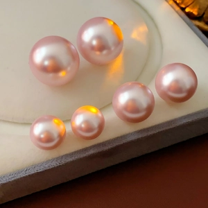Macro shot of high-luster pink-purple round freshwater pearls on jewelry lining