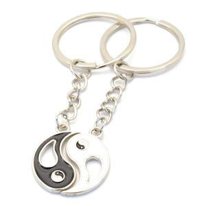 Detailed view of silver metal yin yang pendants on keychains for couples and best friends