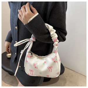 Detail of floral shoulder bag featuring pink roses, bow prints and elegant gathered handle
