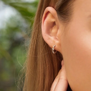 On-ear view of S925 sterling silver geometric beaded hoop earrings on a model
